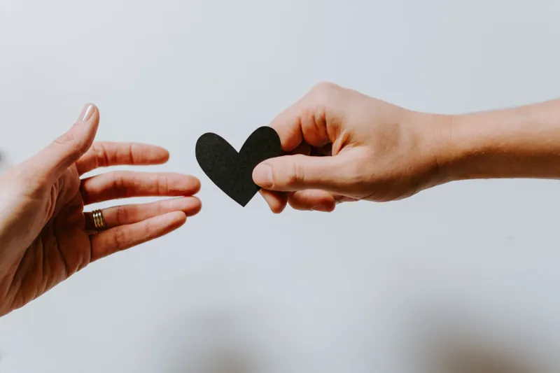 Two hands passing a heart